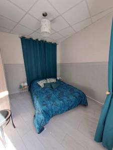 a bedroom with a bed with a blue comforter at Appartement cosy sur Masevaux in Masevaux +9 photos