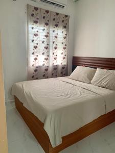 1 dormitorio con 1 cama grande y ventana en Homestay Bajet MokAji, en Kuala Terengganu