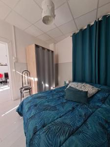 1 dormitorio con cama con sábanas azules y silla en Appartement cosy sur Masevaux, en Masevaux