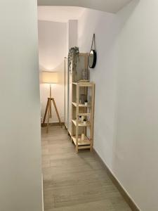 un couloir avec une étagère et une lampe sur un mur dans l'établissement Stylish one bedroom flat in the heart of Madrid, à Madrid