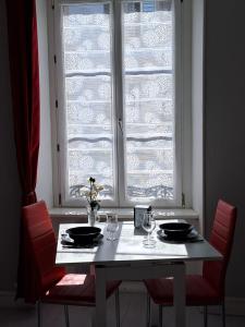 mesa de comedor con 2 sillas y ventana en Appartement cosy sur Masevaux, en Masevaux