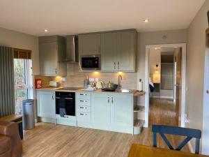a kitchen with white cabinets and a counter top at Acorn Lodge with Hot Tub in Cupar