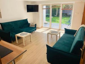 a living room with a green couch and tables at Apartamenty Bałtyckie in Sopot