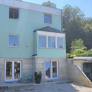 a blue house with windows and a patio at Charmante Waldrandidylle in Kreuzlingen