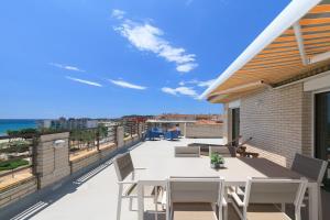 a patio with a table and chairs on a balcony at UHC CASPEL APARTMENTS in La Pineda