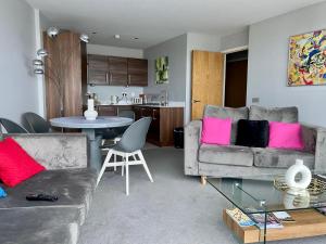 a living room with two couches and a table at Titanic and Sea View Belfast 2 bedroom Apartment City Centre in Belfast