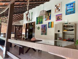 einen Esstisch in einem Zimmer mit Gemälden an der Wand in der Unterkunft Vila Flexal Pousada in Alter do Chao
