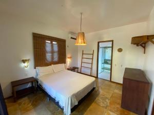 Schlafzimmer mit einem Bett, einem Tisch und einer Leiter in der Unterkunft Condominio Vila dos Ventos in Icaraí + 13 Fotos