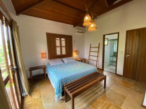 ein Schlafzimmer mit einem Bett und einer Bank in einem Zimmer in der Unterkunft Condominio Vila dos Ventos in Icaraí