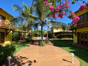 einen Weg, der zu einem Resort mit einer Palme führt in der Unterkunft Condominio Vila dos Ventos in Icaraí