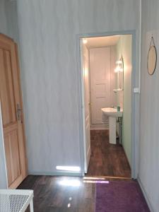 um corredor com uma casa de banho com um lavatório e um espelho em Appartement cosy sur Masevaux em Masevaux