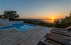 a swimming pool with a sunset in the background at Nice Home In Rovanjska With 6 Bedrooms, Wifi And Jacuzzi in Rovanjska