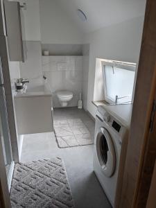 a bathroom with a washing machine and a toilet at Ferienwohnung Genusshaus TIMIschl in Sankt Margarethen an der Raab