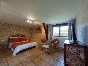 ein Schlafzimmer mit einem Bett und einem TV in der Unterkunft Le Moulin de Bernard in Saint-Pantaléon