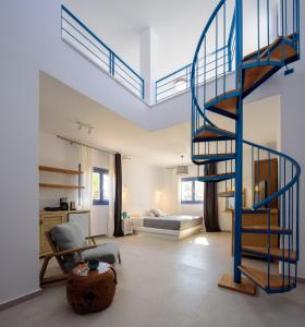 a living room with a spiral staircase and a bedroom at White Dream Suites Antiparos in Antiparos