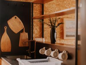 a kitchen with a sink and a shelf with utensils at Aardts Cabins in De Rust
