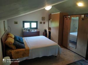 sypialnia z łóżkiem, komodą i lustrem w obiekcie chalet La vigna casa vacanze w mieście Scurcola Marsicana