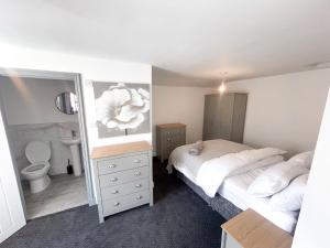 1 Schlafzimmer mit 2 Betten, einem WC und einem Spiegel in der Unterkunft 53 Church Street in Warrington
