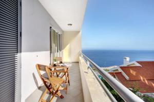 een balkon met een tafel en uitzicht op de oceaan bij Apartamento Fénix Garajau in Caniço