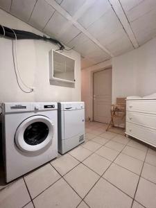 uma lavandaria com uma máquina de lavar roupa num quarto em Jolie Villa du Gaucher - Détente - Calme - Campagne em Cosnac