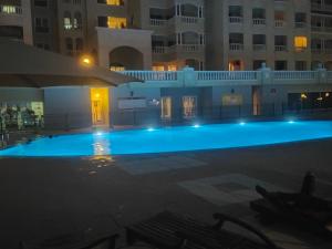 a large swimming pool at night with buildings at Sea View Studio 3 Royal Breeze Breezeسي ويو ستوديو رويال بريز in Ras al Khaimah