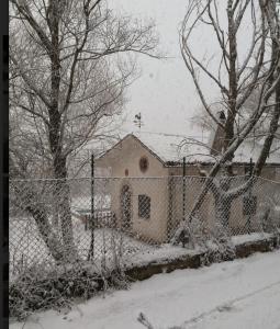 Kościół pokryty śniegiem przed płotem w obiekcie chalet La vigna casa vacanze w mieście Scurcola Marsicana