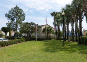 a park with two flags and a building at Disney Holiday Home, Orlando in Kissimmee