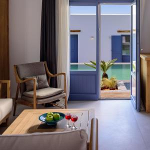 a living room with a table and a view of the ocean at White Dream Suites Antiparos in Antiparos