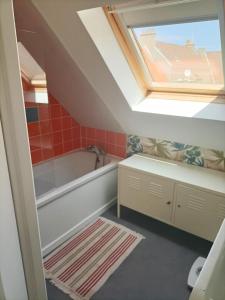a bathroom with a bath tub and a skylight at APPARTEMENT 100 M DE LA PLAGE LE PORTEL in Le Portel