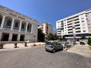 um parque de estacionamento com carros estacionados em frente aos edifícios em 446 Luxury Apartament Center em Shkodër