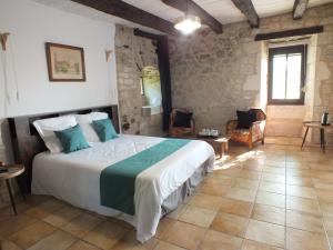 a bedroom with a large bed in a room at Le Moulin de Bernard in Saint-Pantaléon
