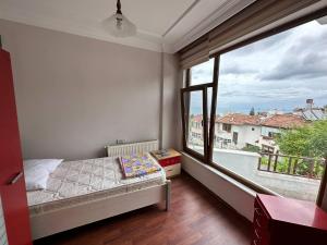 a bedroom with a bed and a large window at Peaceful Villa with Perfect View in the City Center in Trabzon