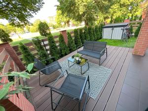 a patio with two chairs and a table and a bench at Lux Garden Apartment in Kołobrzeg