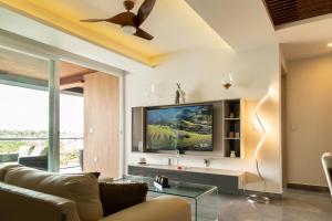 a living room with a couch and a flat screen tv at Fabulous & Exclusive Apartments With Sea View Pool BBQ Garden in Akumal