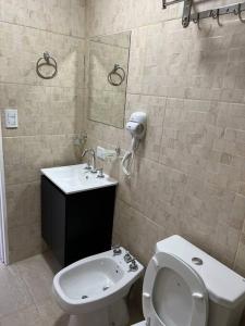 a bathroom with a toilet and a sink and a mirror at apart trelew 1 in Trelew