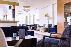 eine Lobby mit Sofas, Tischen und Stühlen in der Unterkunft Apartments Spa Resort Styria- ADULTS ONLY in Bad Waltersdorf