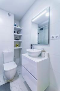 uma casa de banho branca com um lavatório e um espelho em Palangre Beach Apartment em Torrevieja