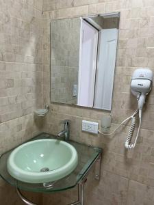 a bathroom with a sink with a mirror and a hair dryer at apart trelew 1 in Trelew