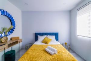 een slaapkamer met een geel bed met een blauw hoofdeinde bij Palangre Beach Apartment in Torrevieja