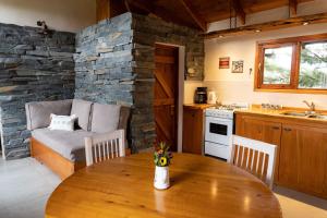 a kitchen and dining room with a table and a couch at Vuelvo al Sur Alojamiento Lago Puelo in Lago Puelo