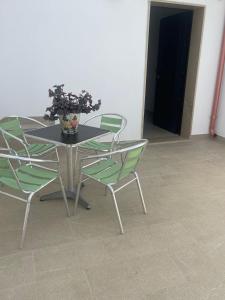 una mesa y sillas con un jarrón de flores. en Virgilio Street, en Borgagne