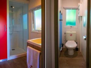 La salle de bains est pourvue de toilettes, d'un lavabo et d'une douche. dans l'établissement Camping de la Forêt Seasonova, à Sillé-le-Guillaume