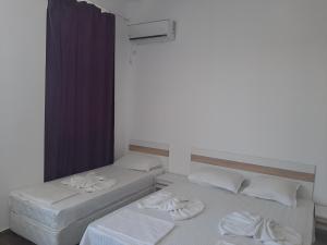 two beds sitting next to each other in a room at Апартаменти Жени in Tsarevo
