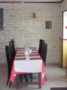 une table à manger avec un tissu de table rouge et blanc dans l'établissement Les Lilas Des Deux Ponts, à Cravant