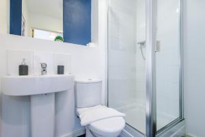 a bathroom with a toilet and a sink and a shower at 2 Bed apartment with balcony private parking near Etihad Stadium, COOP Live in Manchester