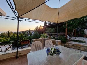 a table and chairs under an umbrella on a patio at Cyprus style Stone Villa in Paphos City