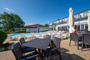 a patio with chairs and tables and umbrellas at Albatros Spa & Ski in Jarosławiec
