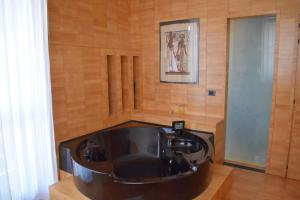 una grande vasca da bagno in una camera con pareti in legno di Casa Macina a CastellʼAlfero