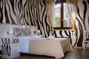 a bedroom with a zebra patterned wall with a bed at GINKÒ Music Hotel in Lequile