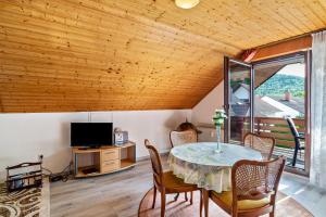 a dining room with a table and a television at Haus Günter und Valeria in Gossersweiler-Stein